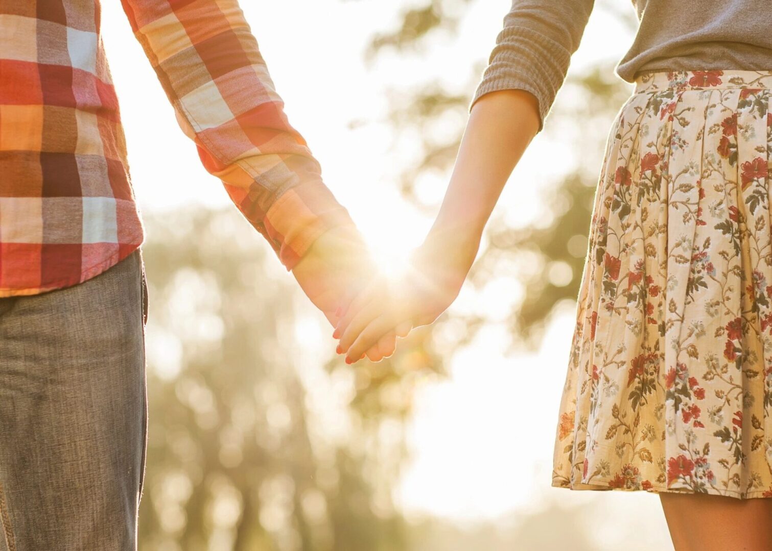 A couple holding hands in the sunlight.